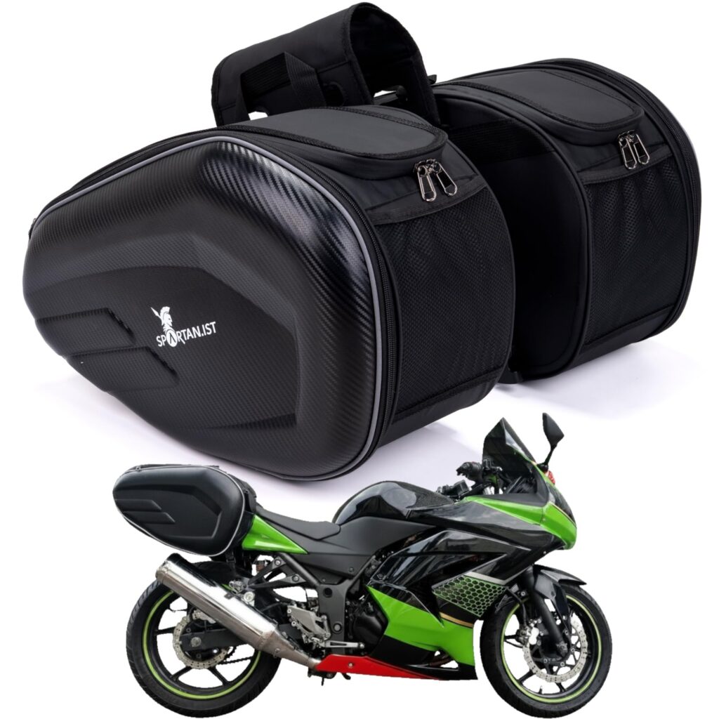 Spartan.ist Premium motorcycle saddlebags in black with a carbon fibre effect outer panel, shown as a pair alongside a green sports bike with the bags fitted to the rear seat.